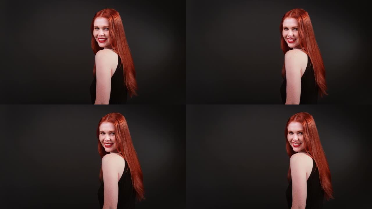 美丽的红发女人，留着健康的长发。用相机调情
