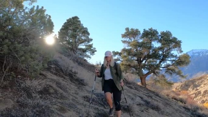 女徒步旅行者穿越沙漠斜坡