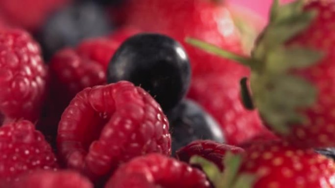成熟多汁的草莓蓝莓覆盆子在许多混合浆果上滚动