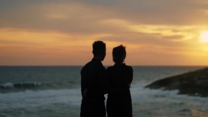 恋爱中的非洲民族浪漫情侣。浪漫的海滩散步看日落