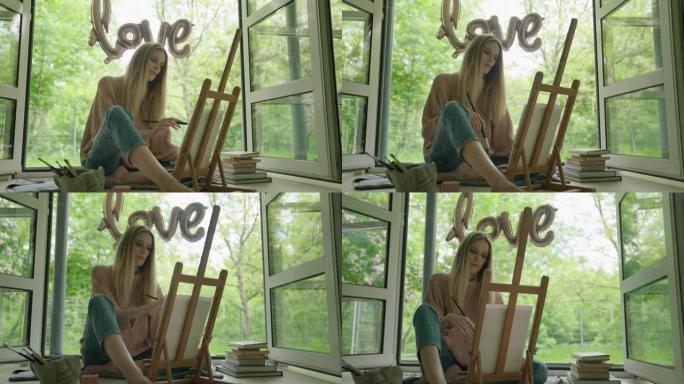 创意时间。女人坐在开着的窗户旁边画一幅画