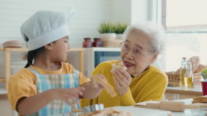 奶奶给孙女喂饼干吃饭就餐用餐祖孙