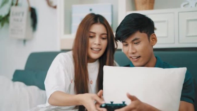 快乐的夫妇喜欢玩电子游戏，在家一起笑。