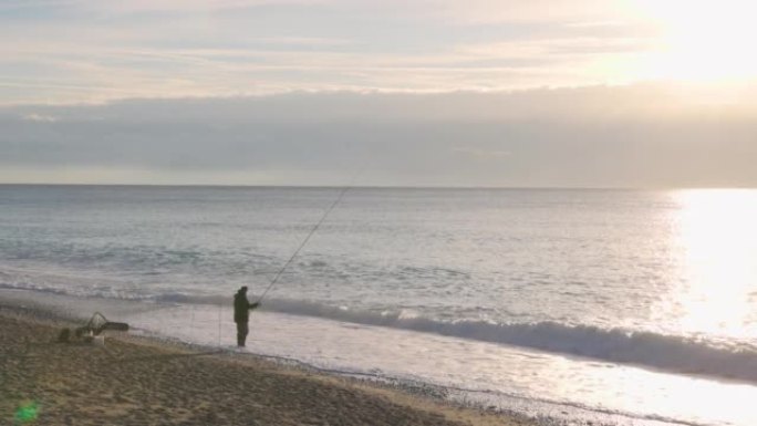 高级渔民从沙质海岸线上投下线