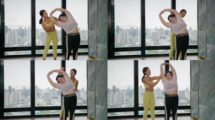 培训师正在教肥胖女性如何正确地做瑜伽。加强身体强壮的能力