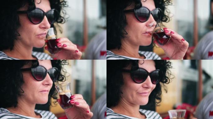 在伊斯坦布尔的加拉塔桥上，用传统的梨形玻璃喝土耳其红茶的女人的特写镜头