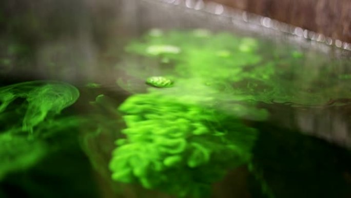 将绿色液体倒入大桶水中的细节镜头