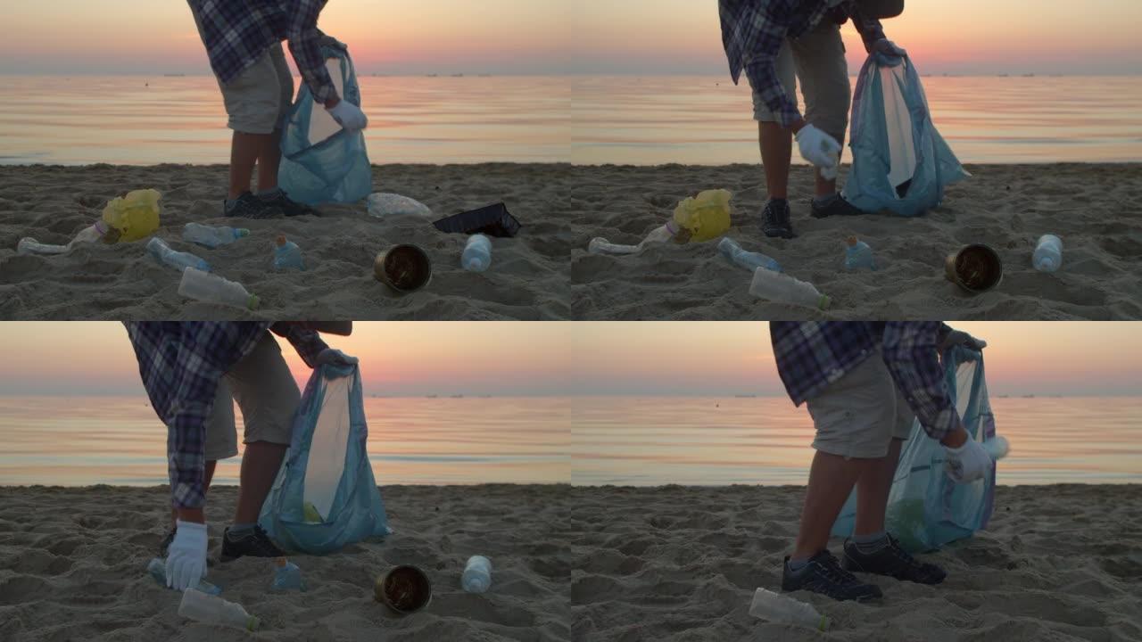 清理塑料垃圾海滩，人收集泥浆并将其扔进袋子。