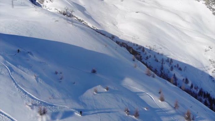 单板滑雪降落在雪山上的空中无人机拍摄