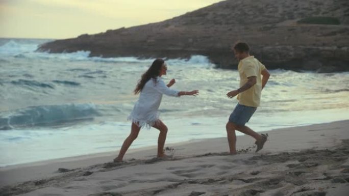 海滩上的浪漫情侣。相爱的情侣牵手玩标签