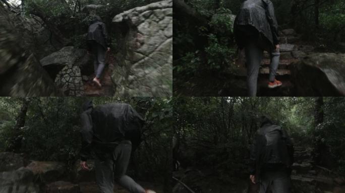 男子在雨中徒步攀登岩石小径