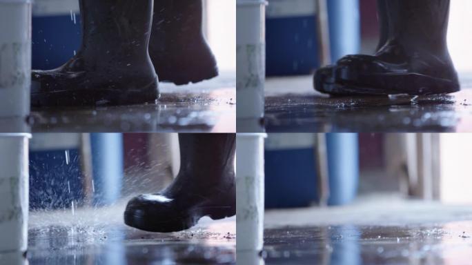 慢动作-液体溅到橡胶靴周围的地板上