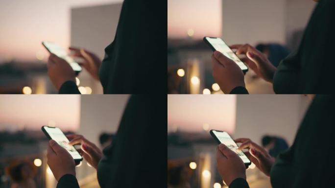 黄昏时女性在智能手机上发短信的特写镜头。
