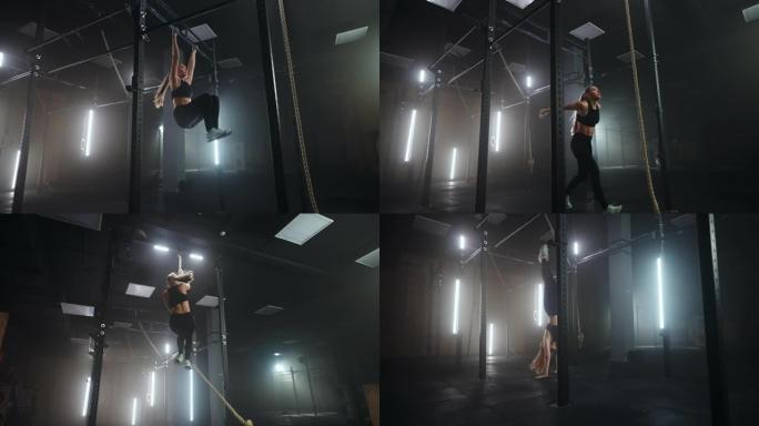 一名女子在体育馆表演攀岩绳的全长广角镜头。体育运动健康成分。交叉健身。一个意志坚定的女运动员正在攀爬