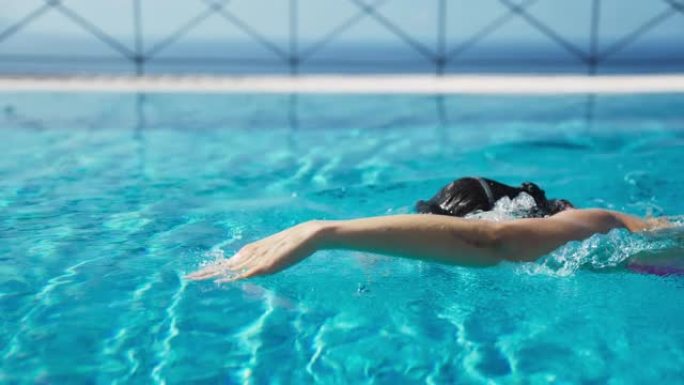 享受无边泳池度假的女人。穿着游泳谷歌