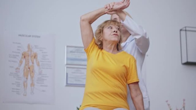 老年女性患者在临床上与医生伸展，身体恢复过程