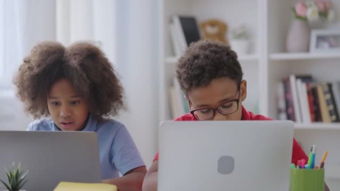 在笔记本电脑上工作的小学生一起解决家庭作业的难题