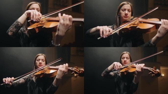 女人在爱乐音乐厅的现场拉小提琴，才女音乐家的肖像