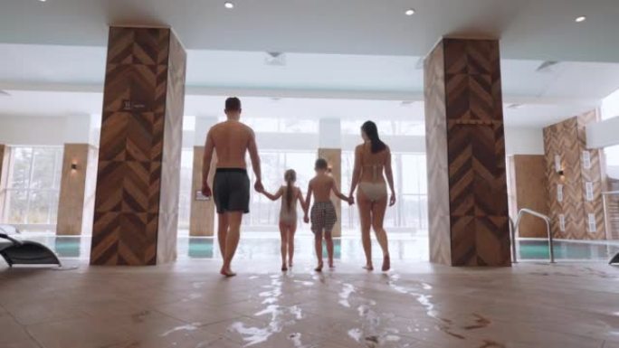 家庭健康中心的欢乐周末，父亲，母亲和两个孩子将去室内游泳池