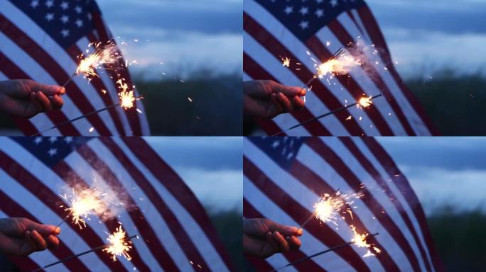 7月4日独立日快乐，手握烟火美国庆祝活动，美国国旗挥舞自然户外背景。概念独立日，烟火，烟火，纪念，退