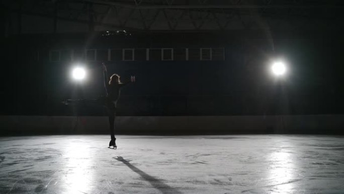 训练职业单人女子花样滑冰运动员，年轻女子独自在溜冰场上滑冰，热身