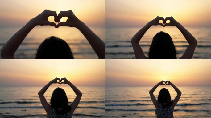 海滩上的年轻女子用手做心形