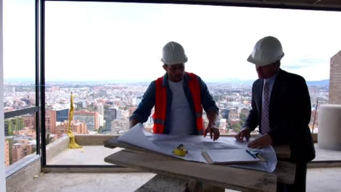 建筑师和工程师在建筑工地项目的简易桌子上查看蓝图