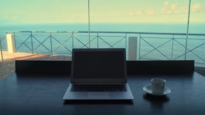 空桌子，有视野和笔记本电脑。舒适的房间，为办公室工作做好准备。海景窗