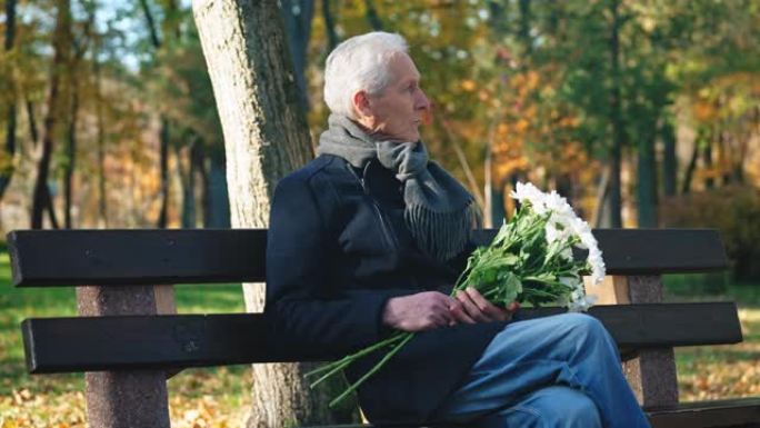 高级男子把花放在长凳上走开，被人站起来约会