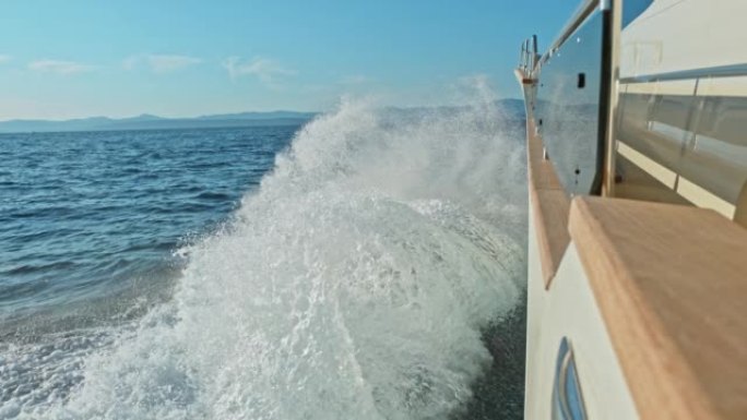 SLO MO LD波浪溅到在海上快速行驶的现代游艇的侧面