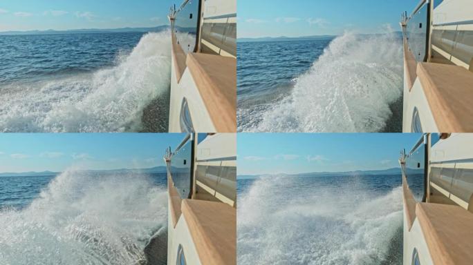SLO MO LD波浪溅到在海上快速行驶的现代游艇的侧面