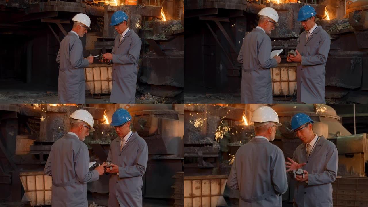 DS两名男工程师看着铸造厂的金属零件并交谈
