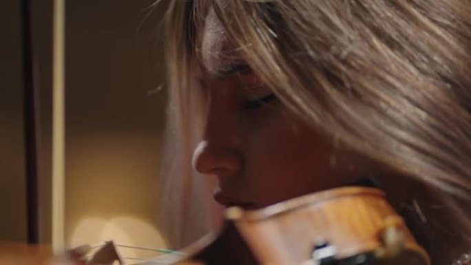 受启发的女音乐家在音乐学校拉小提琴，用小提琴描绘女人