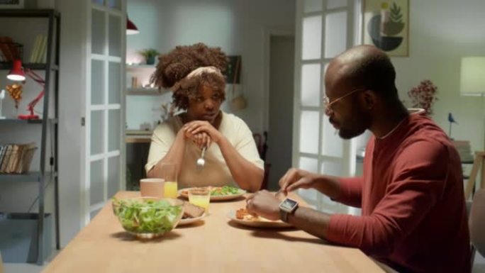 非裔美国夫妇在家里聊天和吃饭