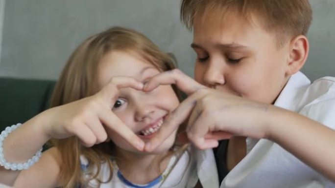 两个白人少女通过双手合十，用手指发出心脏的联合信号。