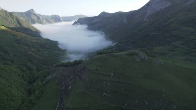 空中无人机在群山环绕的山谷中拍摄低矮的云层