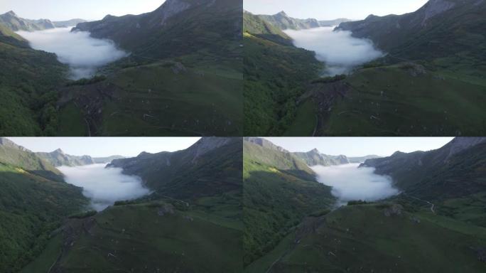 空中无人机在群山环绕的山谷中拍摄低矮的云层