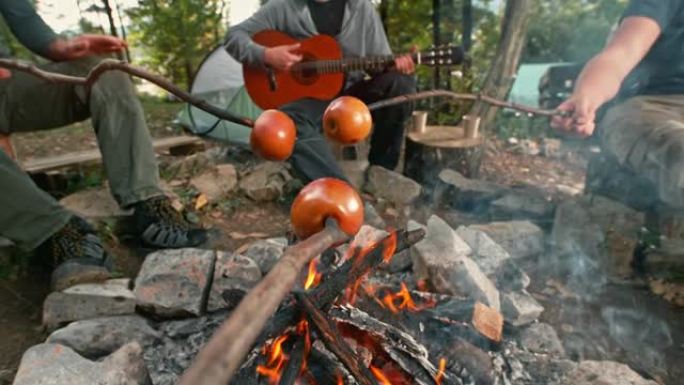 坐在篝火旁烤苹果的SLO MO男人