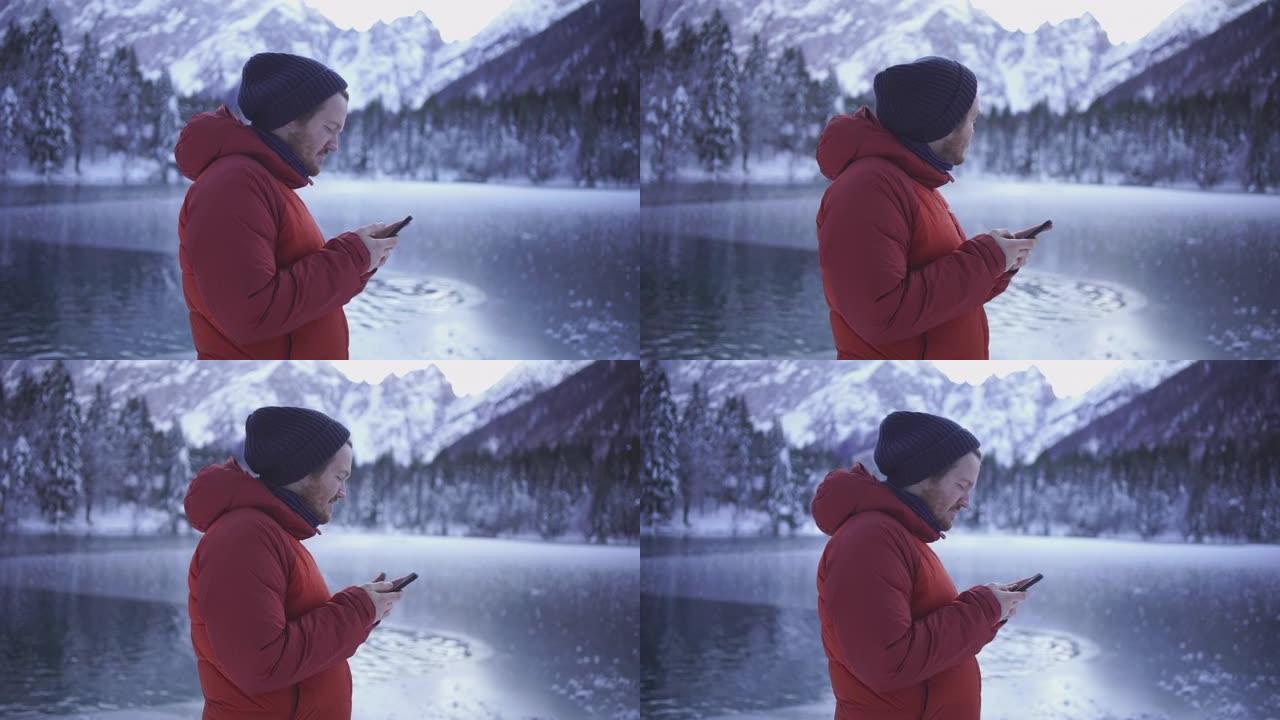 年轻人在白雪皑皑的湖边用手机发短信