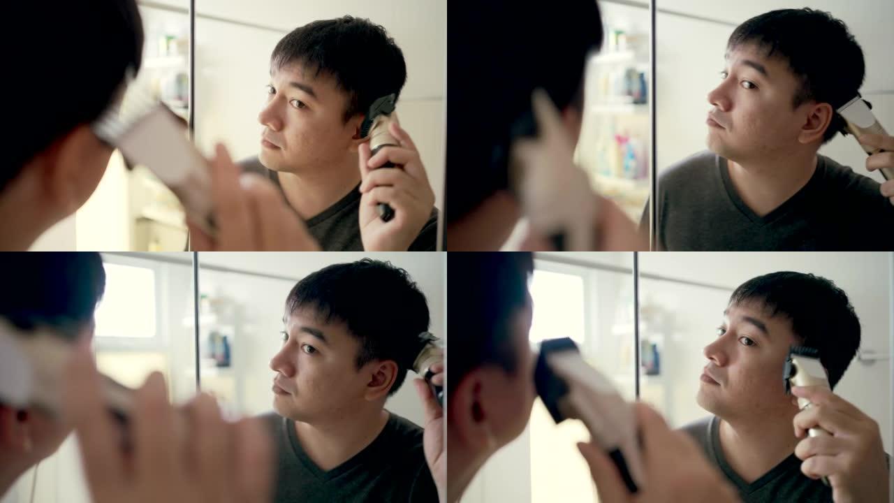 亚洲男人在房子里剪头发，自己动手。