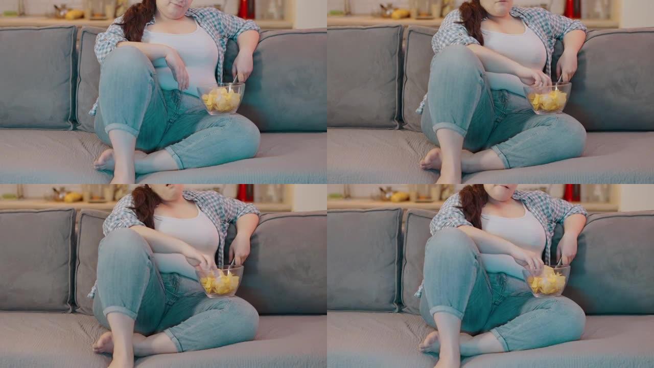 懒惰的肥胖女性吃薯条，改变电视频道，久坐的生活方式