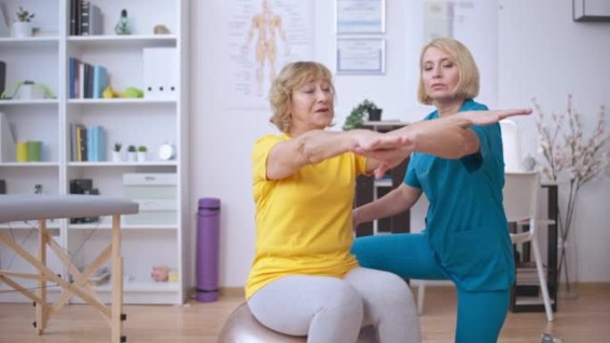 康复中心帮助老年患者健身运动的女护士
