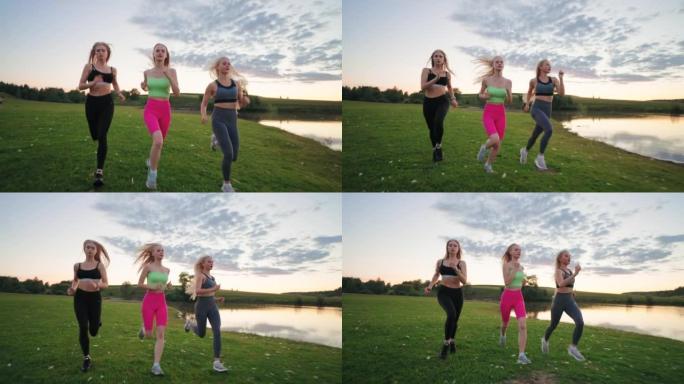 三位迷人的运动女性在美丽的自然景观中慢跑，在日落时在露天训练