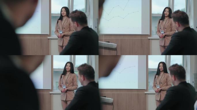 漂亮的黑发女人在会议或商务会议上发言，解释销售图表