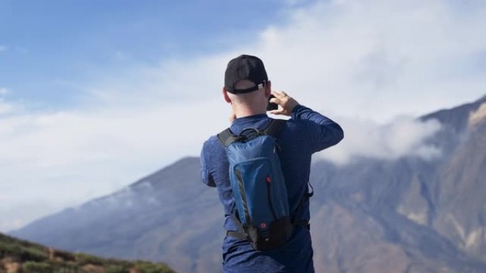 到达顶峰。快乐男人在山顶上拍照