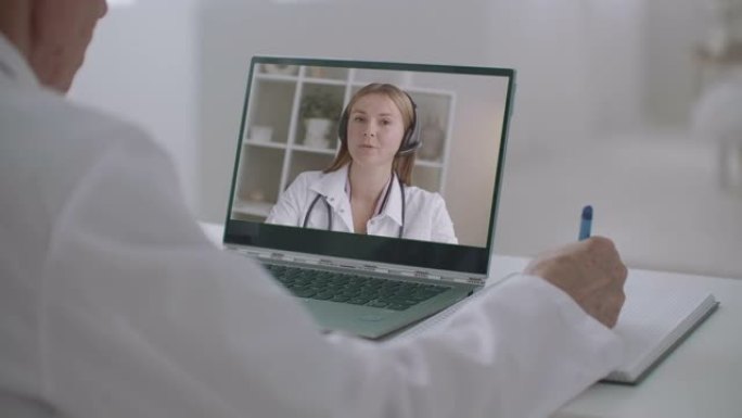 视频会议上的在线医学讲座显示的笔记本电脑，女人在教学，男人在学习