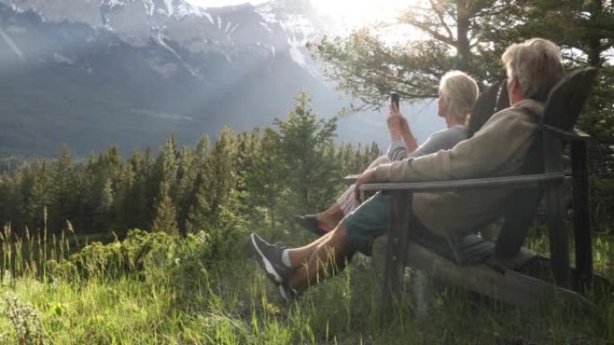 夫妇在木椅上放松，看着森林，山脉