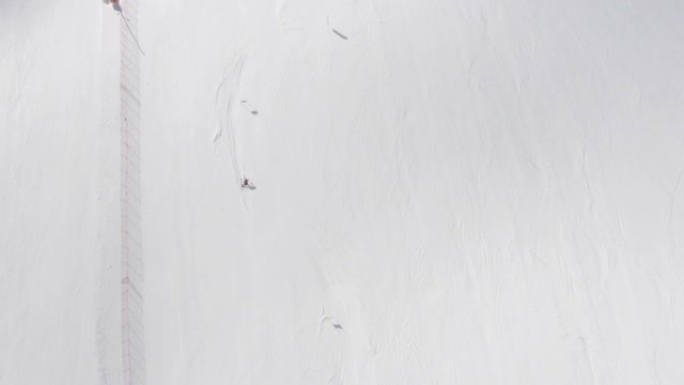 空中无人机在滑雪板上方对着新鲜的雪射击