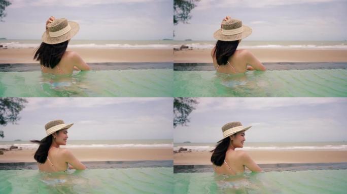 穿着比基尼泳装的亚洲女孩在海滩上的游泳池游泳。