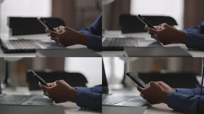 黑人妇女在办公室使用智能手机，用小工具特写镜头，在社交网络中查看新闻磁带，发送消息